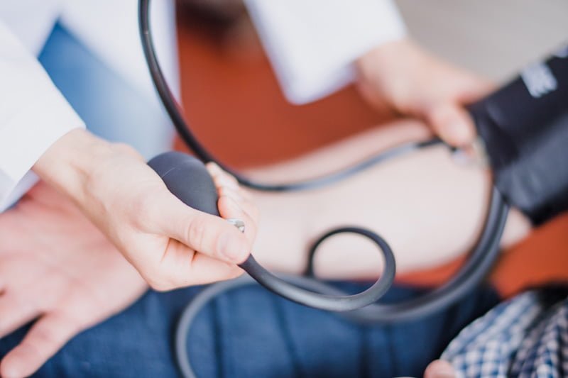 Doctor taking patient's blood pressure
